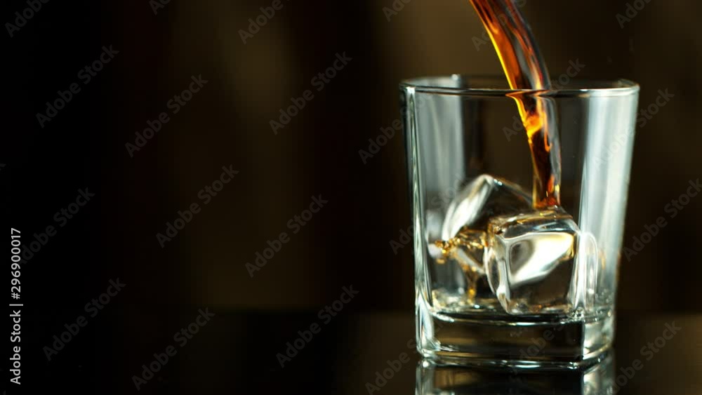 Super Slow Motion Macro Shot of Pouring Whiskey into Glass with Ice Cubes at 1000fps. Filmed on High Speed Cinema Camera in 4K. Super Slow Motion Macro Shot of Pouring Whiskey into Glass with Ice Cubes at 1000fps. Filmed on High Speed Cinema Camera in 4K.