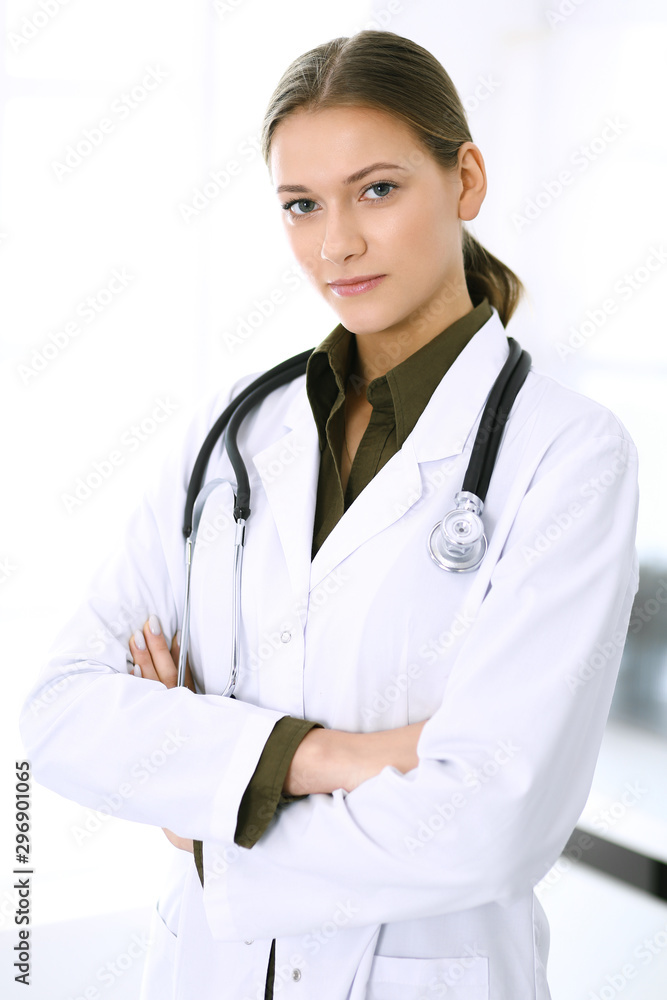 Doctor woman standing straight and looking at camera. Perfect medical service in clinic. Happy future in medicine and healthcare Doctor woman standing straight and looking at camera. Perfect medical service in clinic. Happy future in medicine and healthcare