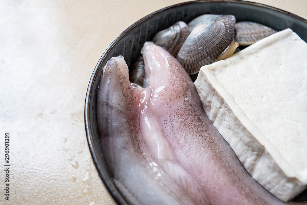 Obraz premium A bowl of fresh ingredients for making soup, fish buds and tofu