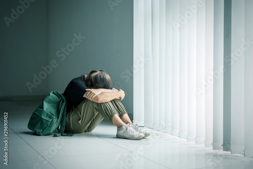 Teenage girl crying near the window © Creativa Images