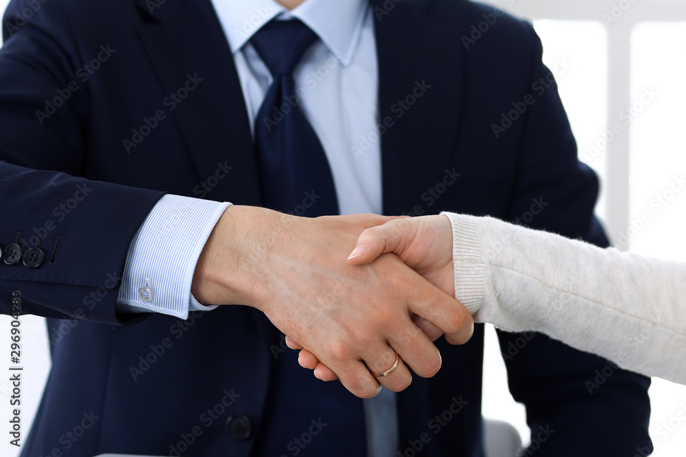 Business people shaking hands after contract signing at the glass desk in modern office. Unknown businessman, male entrepreneur with colleagues at meeting or negotiation. Teamwork, partnership and