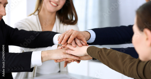 Fototapeta Naklejka Na Ścianę i Meble -  Business people group showing teamwork and joining hands or giving five after signing contract in modern office. Unknown businessman and woman with colleagues or lawyers making circle with their hands