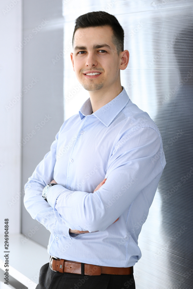 Businessman standing and looking at camera in office. Headshot of casual dressed guy Businessman standing and looking at camera in office. Headshot of casual dressed guy