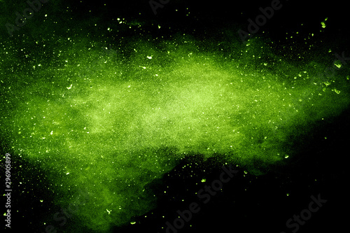 Green powder explosion on black background.Green dust particles splash.