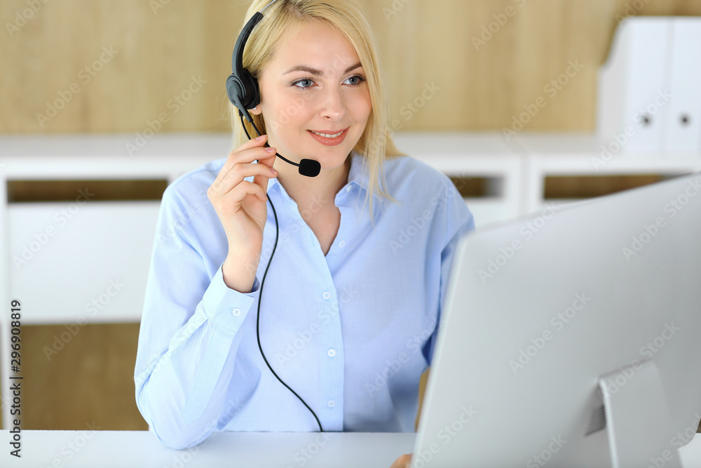 Call center. Blonde business woman sitting in headset at customer service office. Concept of telesales business or home office occupation Call center. Blonde business woman sitting in headset at customer service office. Concept of telesales business or home office occupation