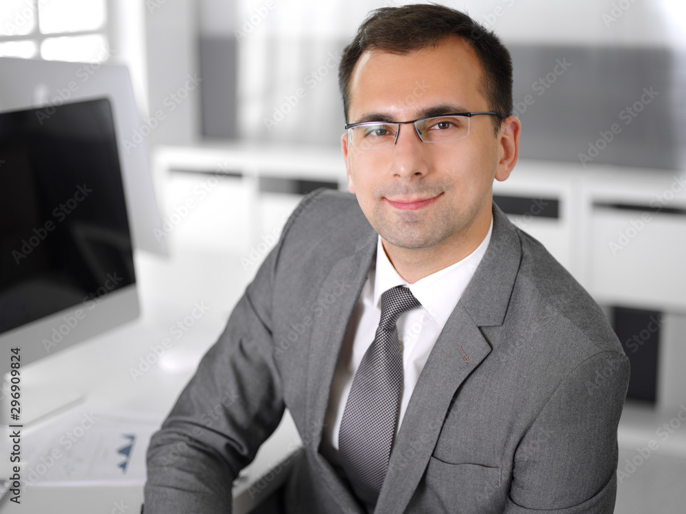 Businessman headshot at meeting in modern office. Entrepreneur sitting at the table with colleagues. Teamwork and partnership concept. Grey blazer suits to happy smiling manager Businessman headshot at meeting in modern office. Entrepreneur sitting at the table with colleagues. Teamwork and partnership concept. Grey blazer suits to happy smiling manager