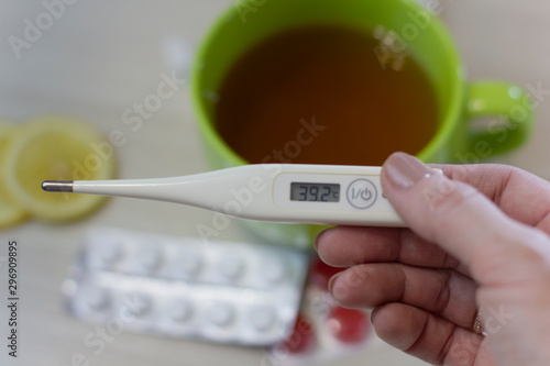 A cup of hot tea with a lemon. Treatment of colds and flu. A flu medicaments, thermometer, pills and paper wipes