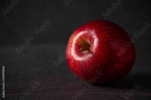red apple against black stone background with space for text