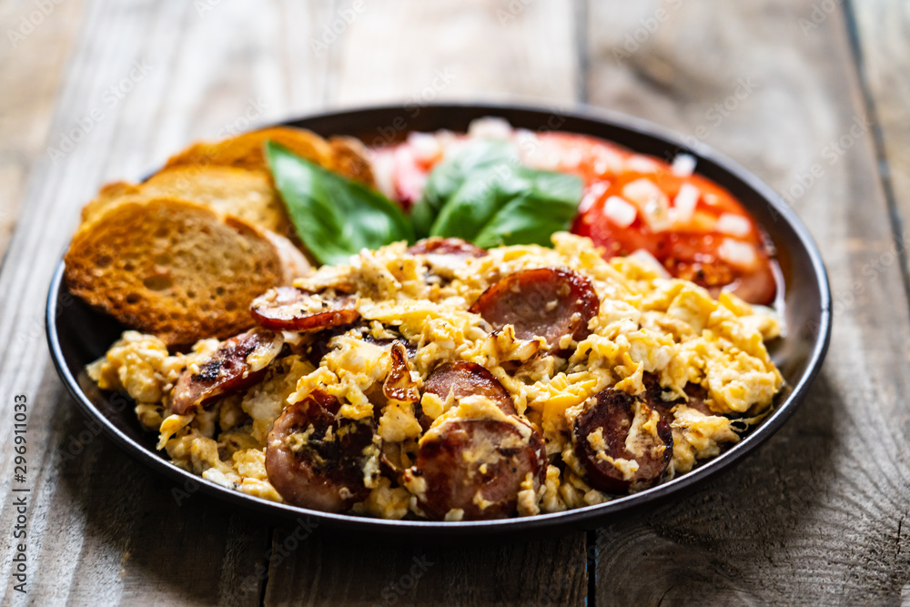 Breakfast - scrambled eggs with sausage and toasts Breakfast - scrambled eggs with sausage and toasts