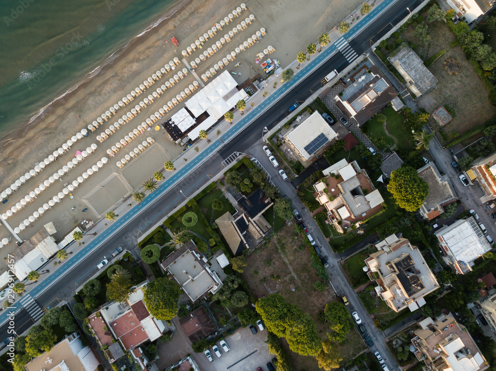 Fototapeta premium Top view of a coastal town with a beach and beach umbrellas. Terracina, Province of Latina, Lazio Region, Italy
