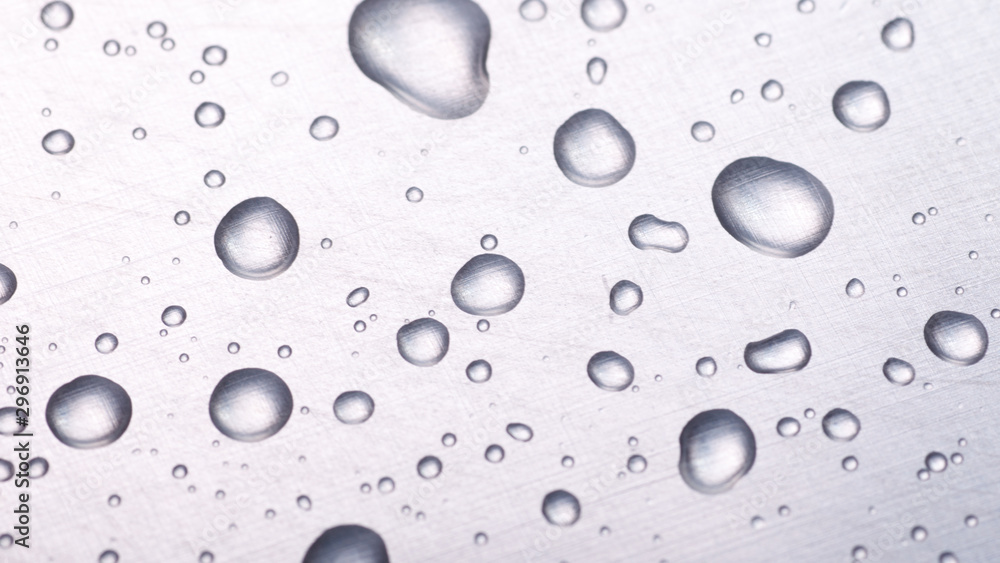 dots of water on light metal surface, macro background, horizontal shot