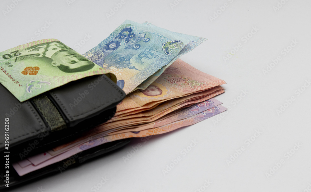 Many Thai banknotes in a wallet placed on a white background. Concept interpretation of means to expand Whether saving money or investing For the growth to grow even more For stability in the future Many Thai banknotes in a wallet placed on a white background. Concept interpretation of means to expand Whether saving money or investing For the growth to grow even more For stability in the future