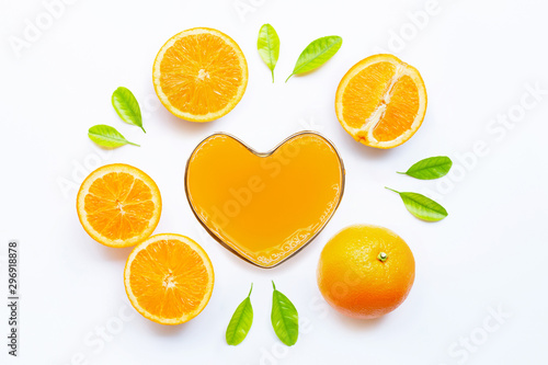 Heart shape glass of fresh orange juice with orange fruit on white background. Top view