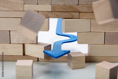 Arrow Breaking Through Wall Made Of Wooden Blocks photo