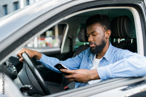 Young male African American holding his phone while drive his car © F8  \ Suport Ukraine