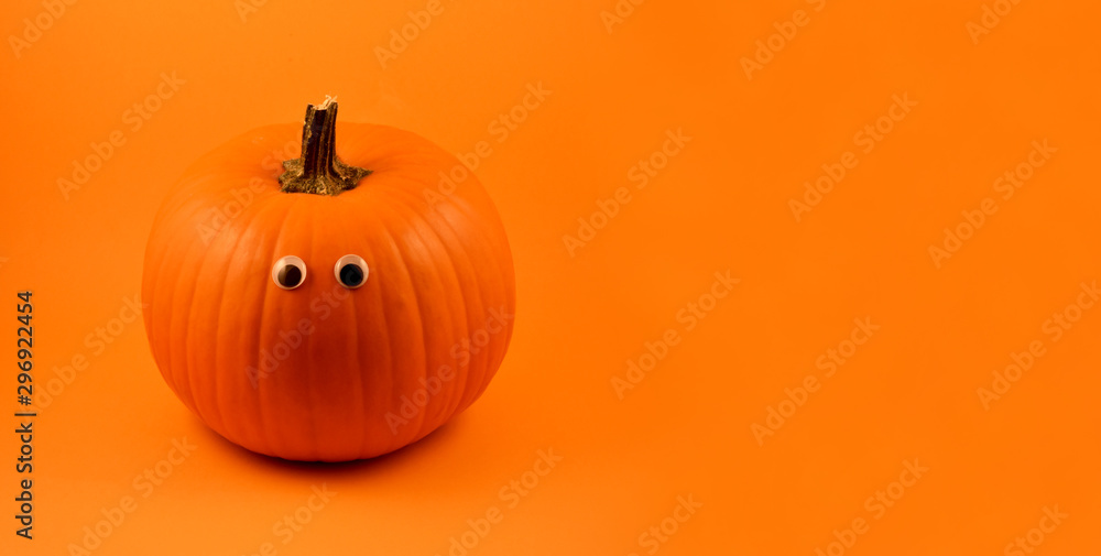 Cute Halloween pumpkin with googly eyes stock images. Halloween pumpkin with googly eyes on a orange background. Halloween pumpkin on a orange background with copy space for text Cute Halloween pumpkin with googly eyes stock images. Halloween pumpkin with googly eyes on a orange background. Halloween pumpkin on a orange background with copy space for text