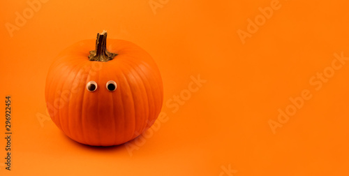 Cute Halloween pumpkin with googly eyes stock images. Halloween pumpkin with googly eyes on a orange background. Halloween pumpkin on a orange background with copy space for text