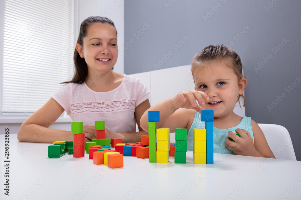 Fototapeta premium Daycare Worker Playing With Colorful Wooden Toy Blocks