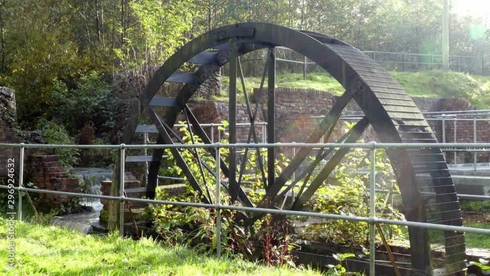 British mining wheel industrial gears in nature reserve canal parkland. Mist passing across static sunlight scenery. British mining wheel industrial gears in nature reserve canal parkland. Mist passing across static sunlight scenery.