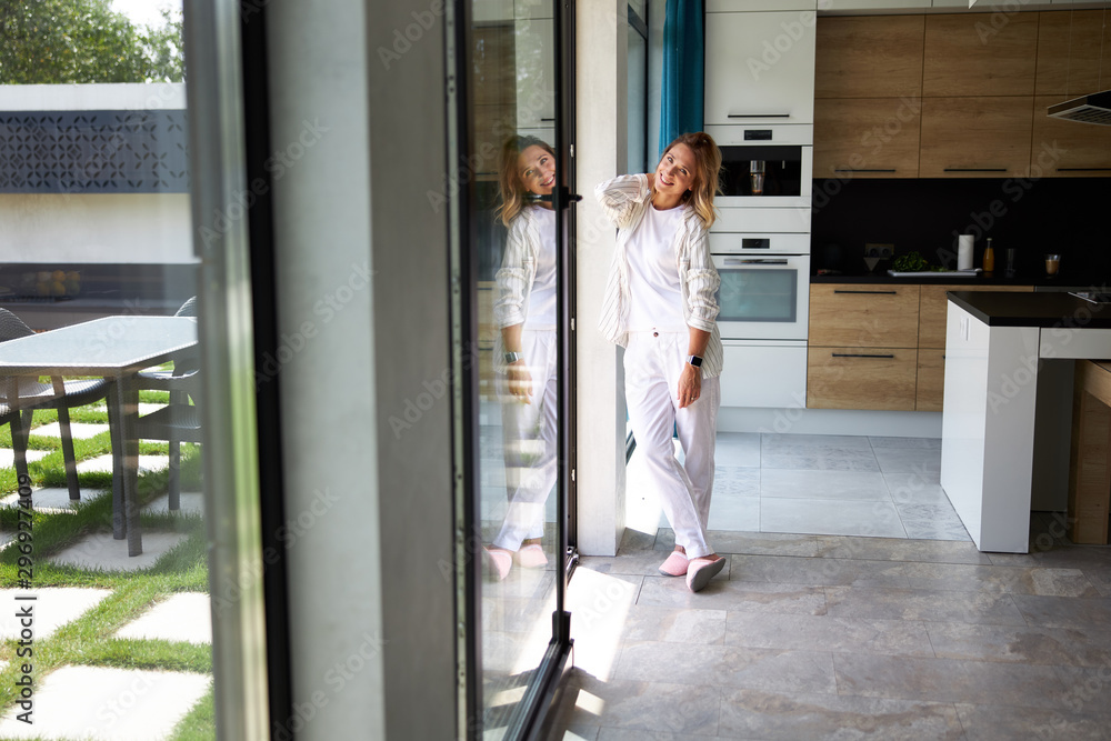 Smiling young woman posing near window at home Smiling young woman posing near window at home