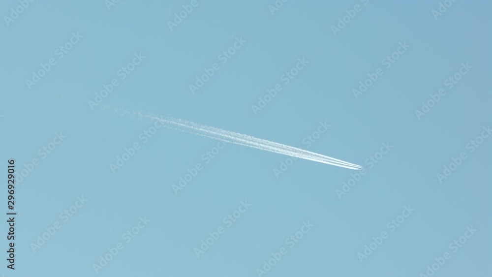 Water vapor contrail behind an airplane flying overhead