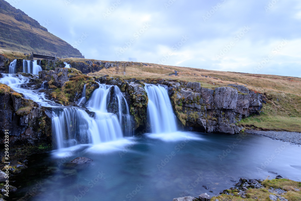 Fototapeta premium Iceland timelapse photography of waterfall and famous mountain. Kirkjufellsfoss and Kirkjufell in northern Iceland nature landscape