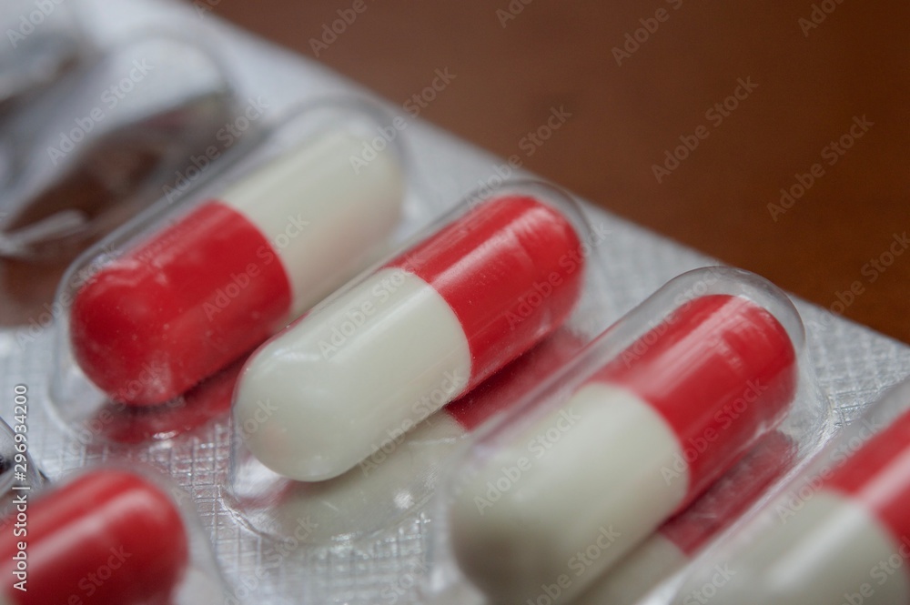 Medication capsules in macro view and dark brown background Medication capsules in macro view and dark brown background