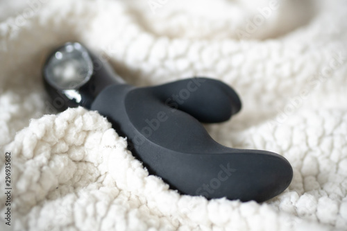 Black sex toy on the bed.