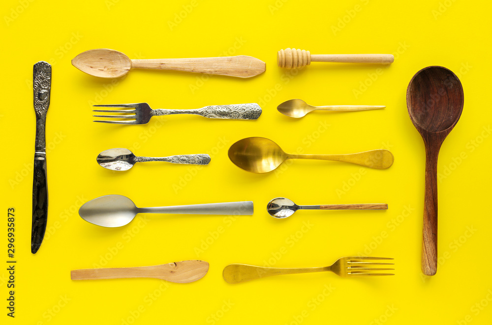 Spoons and forks on yellow background