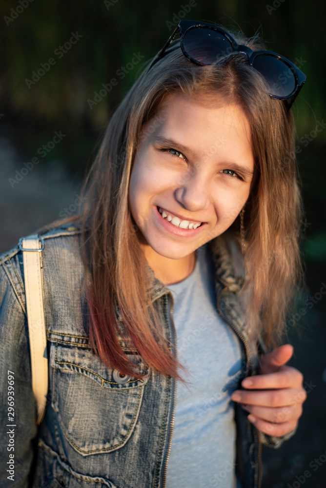 Φωτογραφία Vertical portrait of a smiling teen girl, coming home from school and resting after class