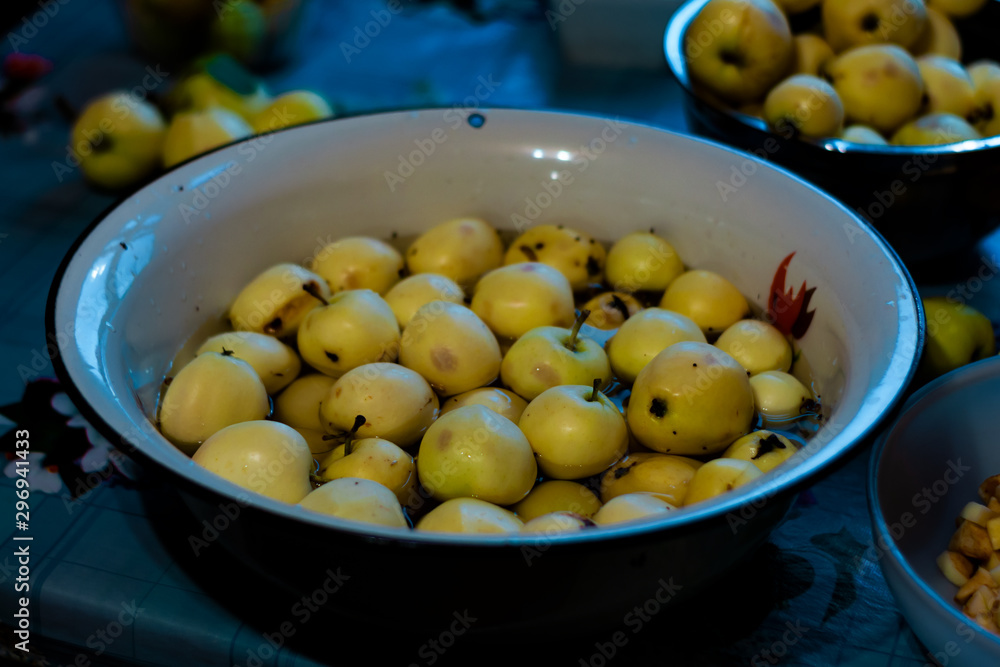 many yellow fresh apples lying in a basin on the table. harvesting. many yellow fresh apples lying in a basin on the table. harvesting.