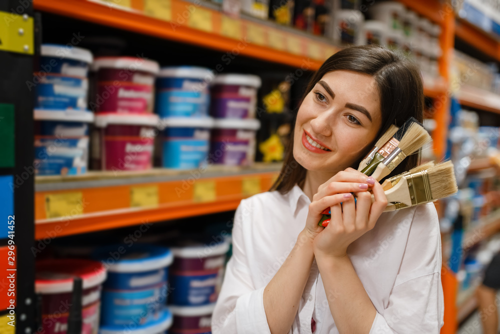 Female customer choosing brush in hardware store Female customer choosing brush in hardware store