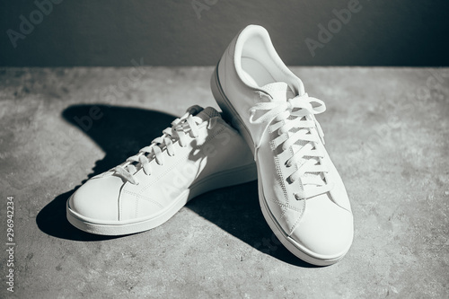 White sneakers on gray background. Stylish white sneakers