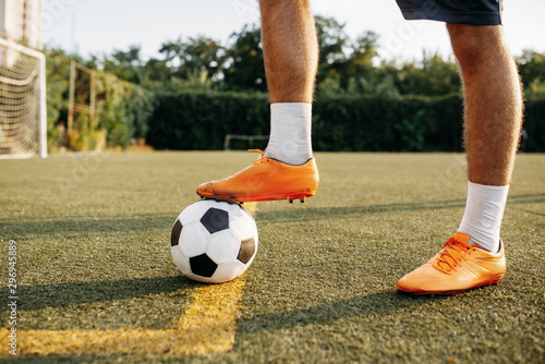 Fototapeta Naklejka Na Ścianę i Meble -  Male soccer player legs with ball standing on line