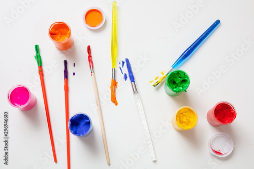 Colorful finger paints set on white color background, top view