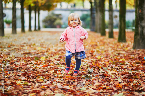 Adorable cheerful toddler girl running in Tuileries garden in Paris  France