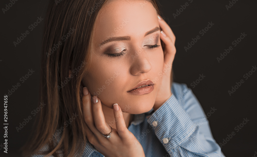 Beautiful young blonde women posing on the black background in blue shirt Beautiful young blonde women posing on the black background in blue shirt