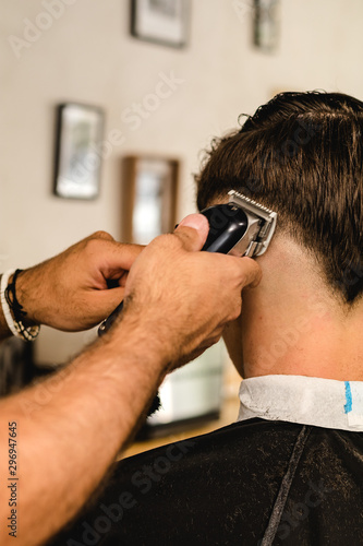 Young Handsome Barber Making Haircut Of teenager Man In Barbershop