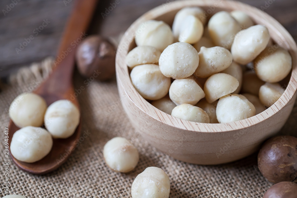 Macadamia nuts on sackcloth and wooden background Macadamia nuts on sackcloth and wooden background