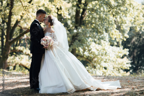 Stylish bride and groom gently kissing Fototapet