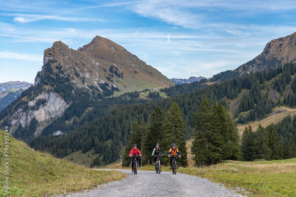 Fototapeta premium three happy senior adults, riding their mountain bikes in the autumnal atmosphere of the Bregenz Wald mountains near Mellau, Vorarlberg, Austria