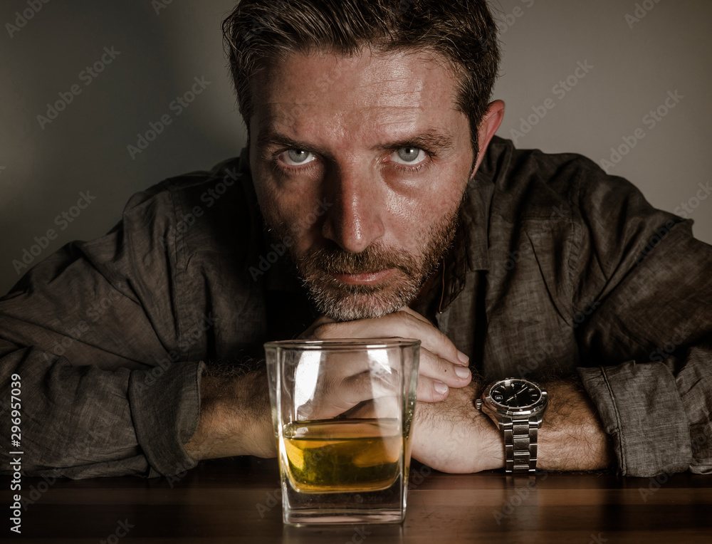 depressed and thoughtful alcoholic man on his 40s in front of whiskey glass wasted and stressed holding on temptation to drink in alcohol addiction and alcoholism problem depressed and thoughtful alcoholic man on his 40s in front of whiskey glass wasted and stressed holding on temptation to drink in alcohol addiction and alcoholism problem