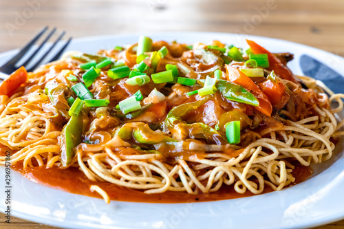 American Chopsuey served in a white plate on wooden surface