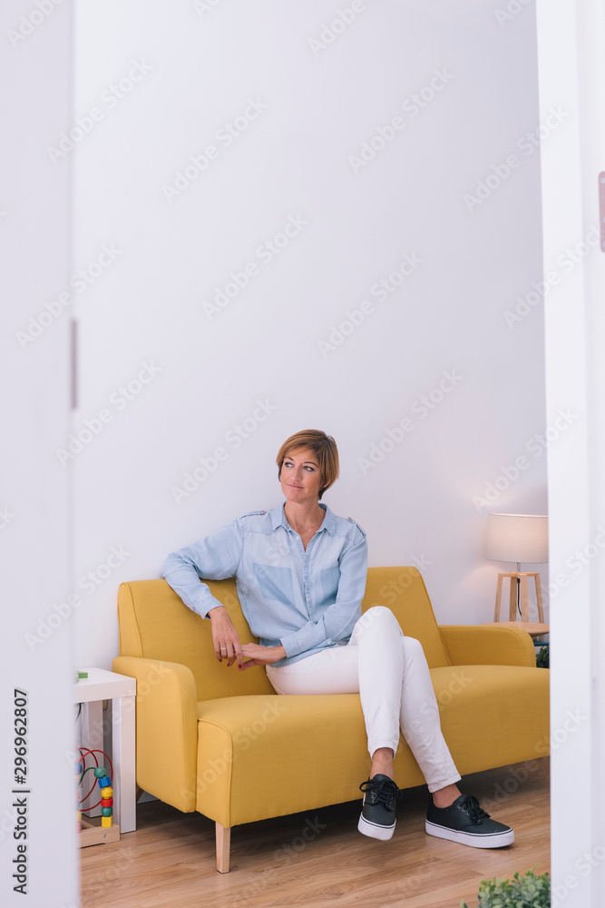 Portrait of an isolated woman at a start up. Co working modern lifestyle. Beautiful young isolated woman working working on couch. Carefree attitude smiling with hope and copy space. Portrait of an isolated woman at a start up. Co working modern lifestyle. Beautiful young isolated woman working working on couch. Carefree attitude smiling with hope and copy space.