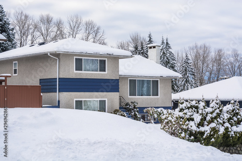 Family residential house with front yard in snow on winter cloudy day