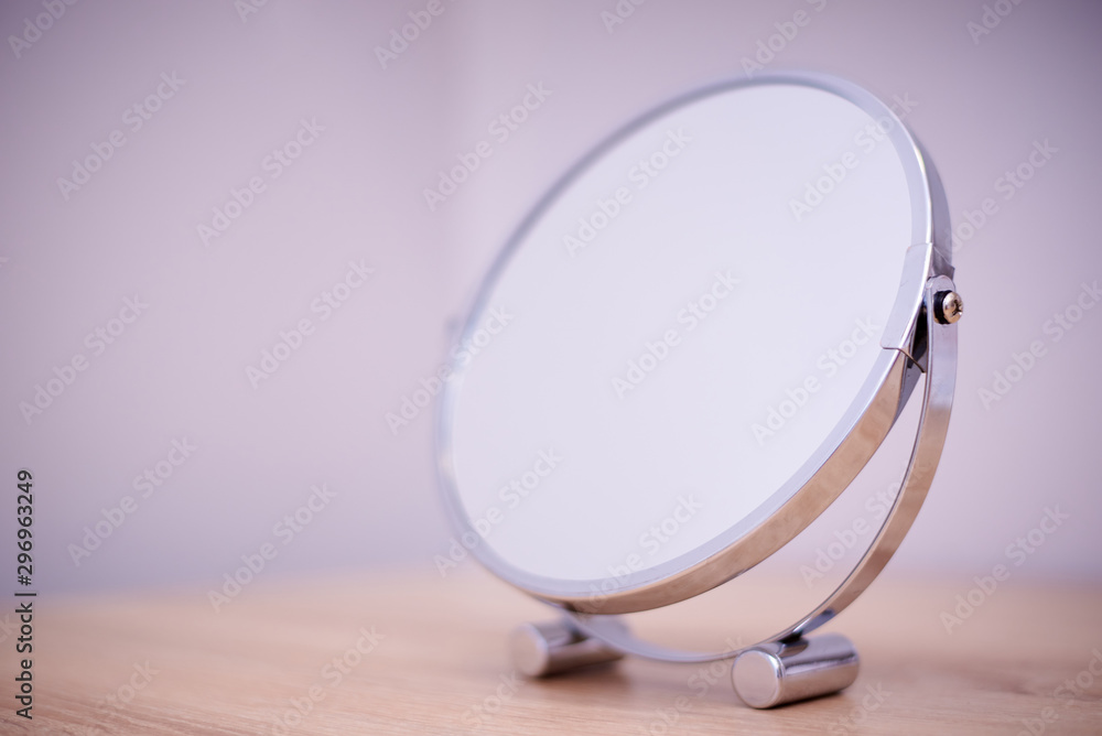 Round mirror on the table close-up. Copy space.