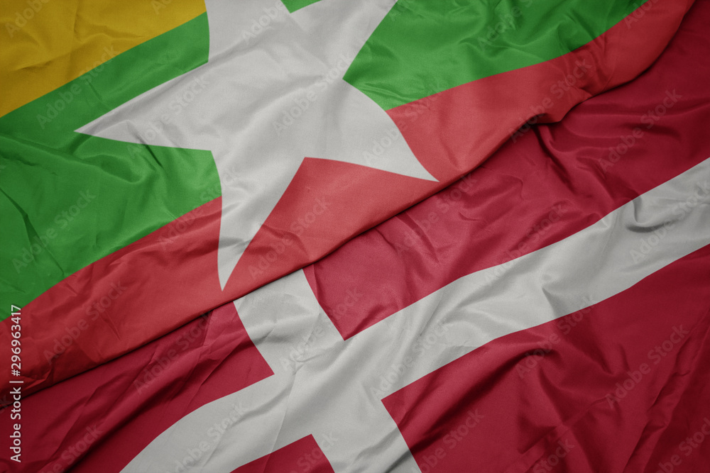 waving colorful flag of denmark and national flag of myanmar.
