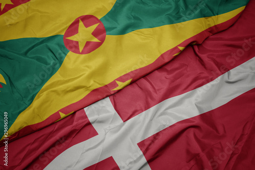 waving colorful flag of denmark and national flag of grenada.
