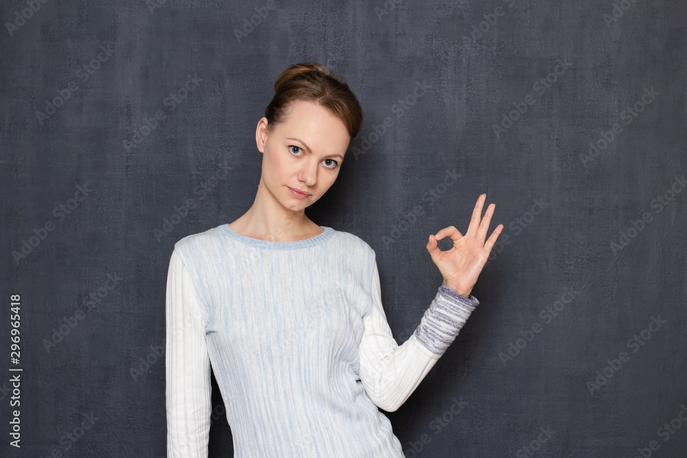 Portrait of serious focused girl showing okay or zero gesture Portrait of serious focused girl showing okay or zero gesture