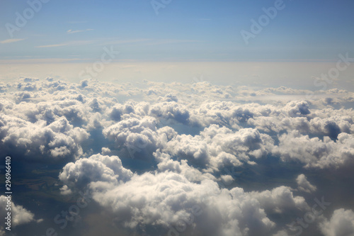 Fluffy clouds texture on blue sky background. View from the window an airplane.